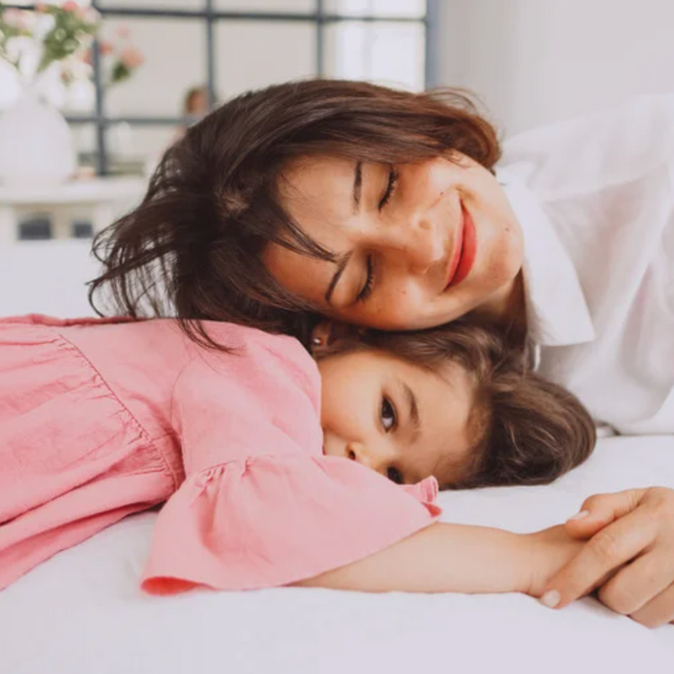 Enfant qui rit pendant un moment de soin ou de coiffage, geste simple et bienveillant au quotidien.