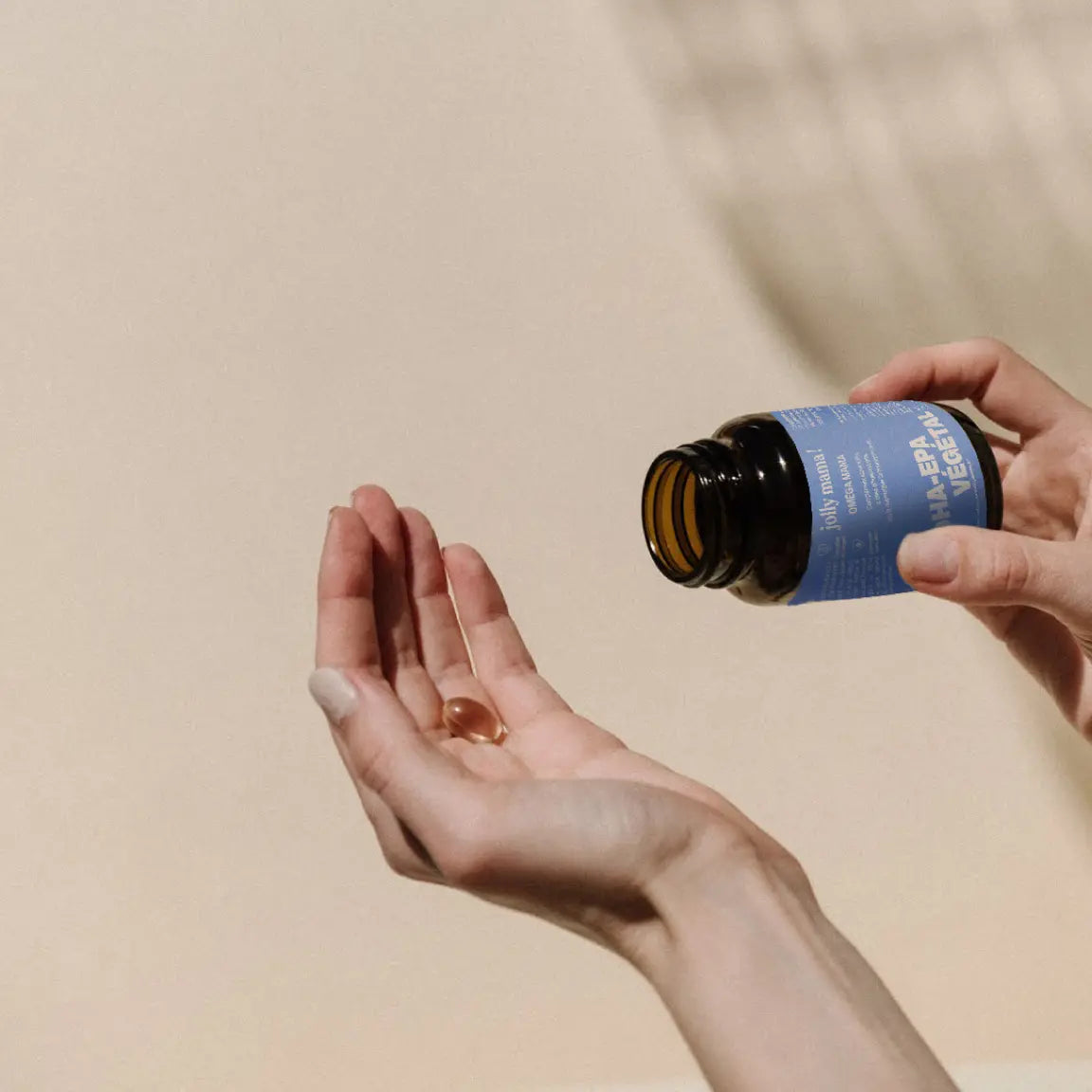 Capsule d’oméga‑3 tenue dans une main, source vegan de micro‑algues, sans odeur de poisson, fabriqué en France.