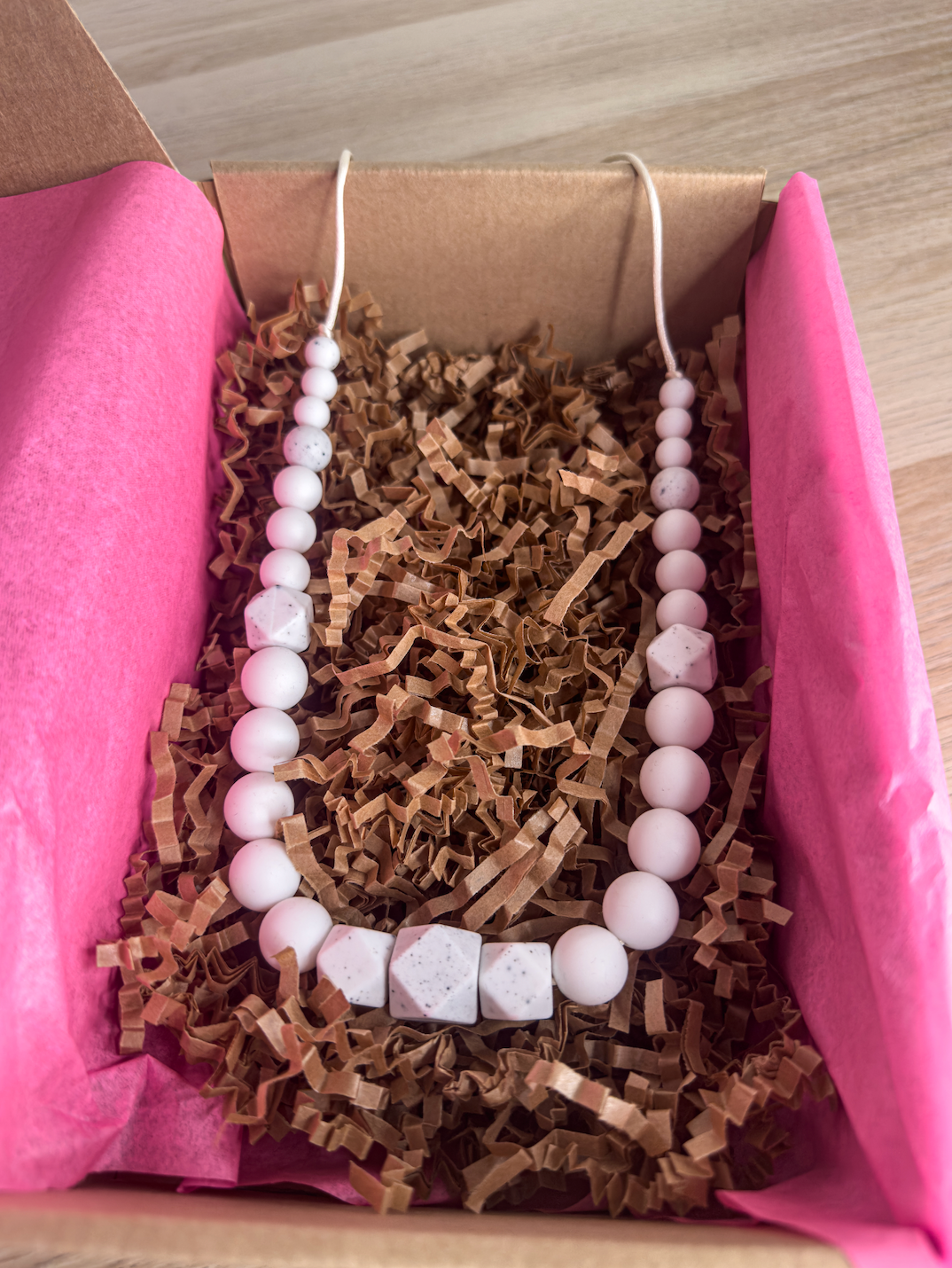Collier d’allaitement élégant avec des perles blanches façon poussière d’étoile, idéal pour maman et bébé.