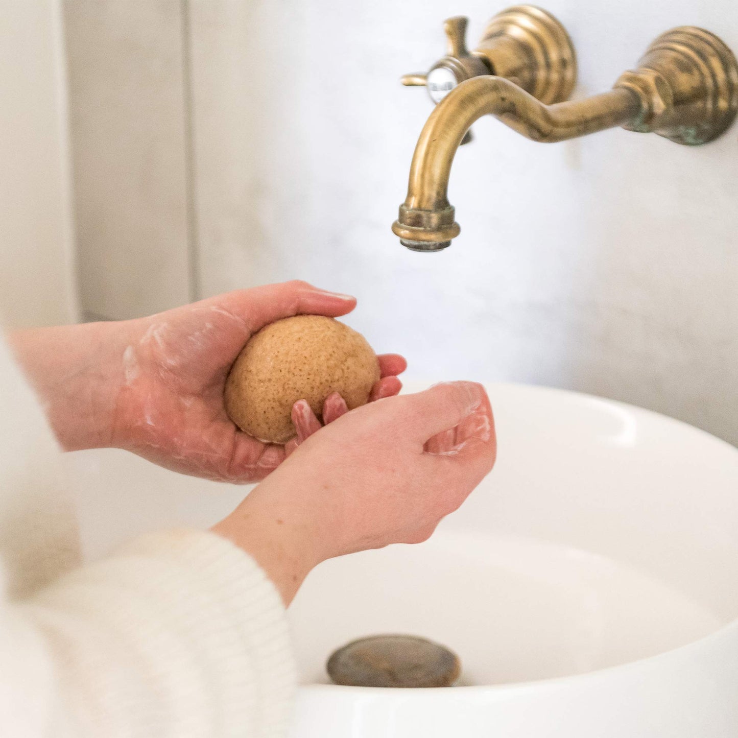 Femme utilisant l’éponge Konjac Omum pour nettoyer et purifier sa peau en douceur.