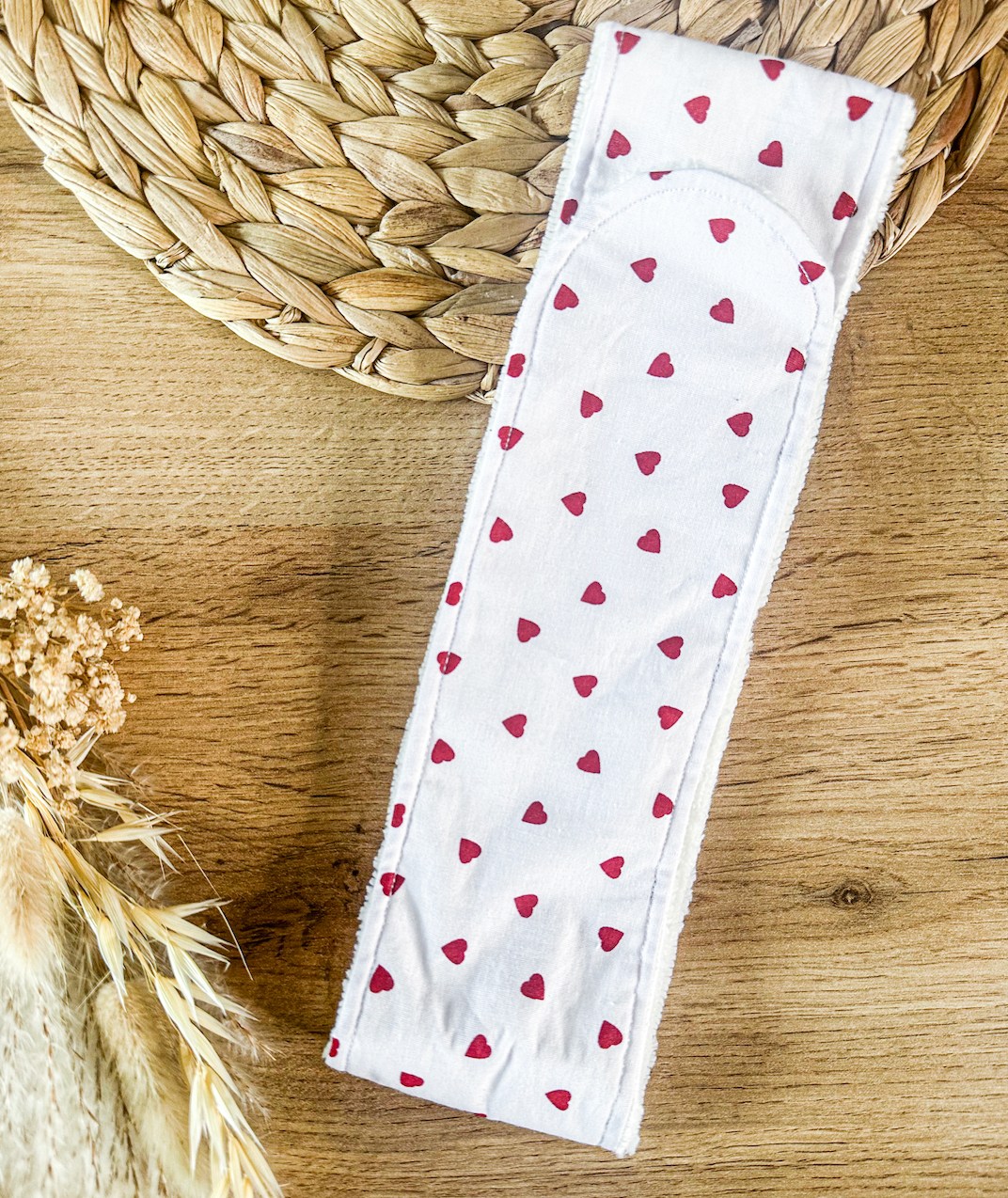 Détail du bandeau pour soins visage, en tissu coton motif cœurs rouges, lavable et réutilisable.