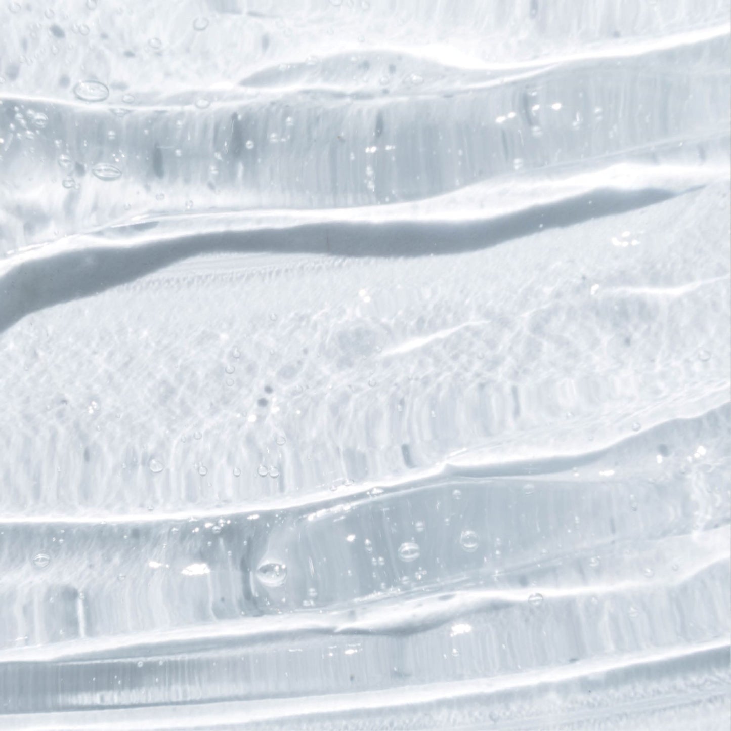 Gros plan de la texture transparente du gel intime Omum, soin doux et hydratant respectueux des muqueuses sensibles.