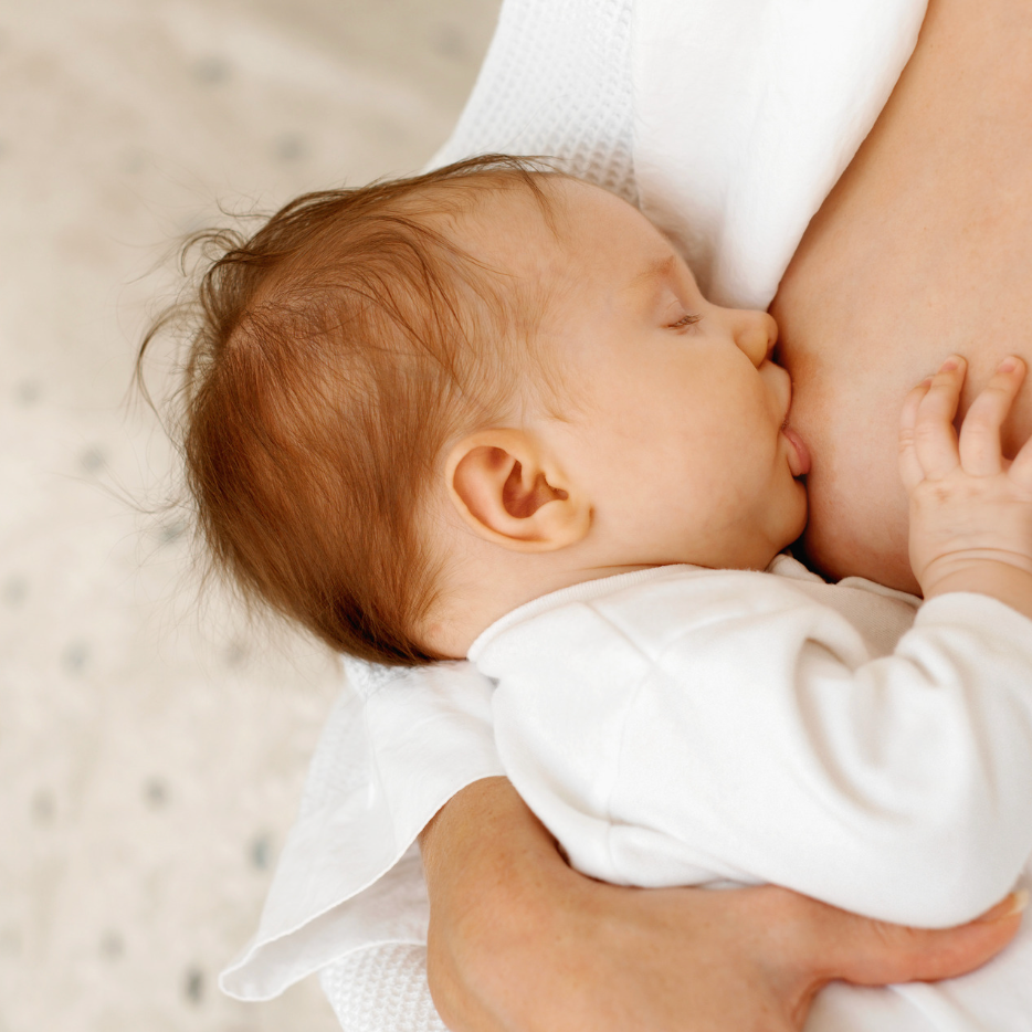 Maman qui allaite son bébé dans un moment de calme et de tendresse, illustrant l’allaitement au quotidien