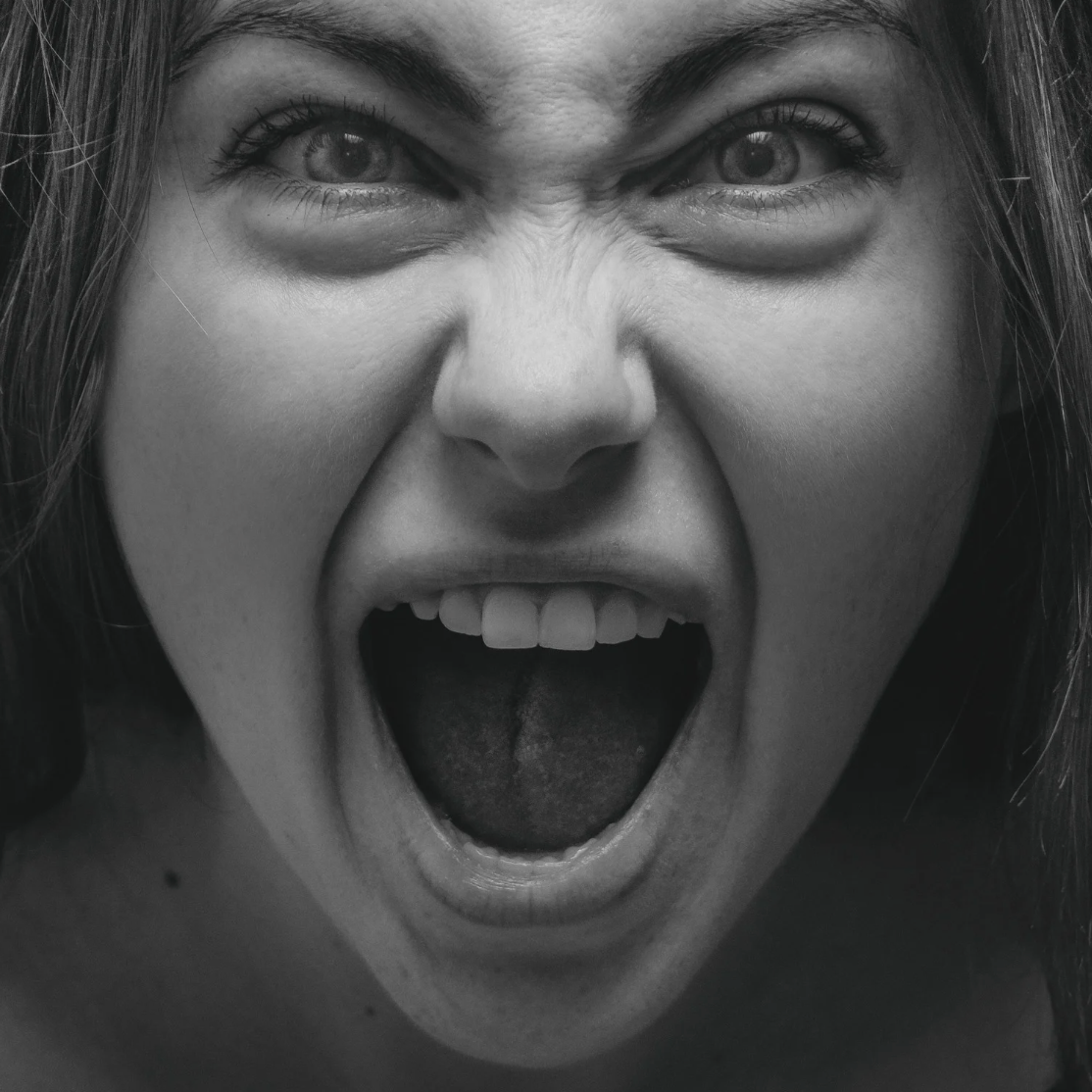 Femme en post-partum qui crie, illustrant la charge mentale et la détresse émotionnelle des jeunes mamans
