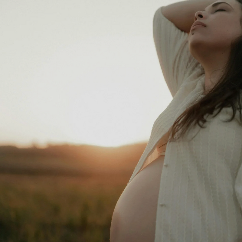 Femme enceinte au coucher du soleil début de grossesse
