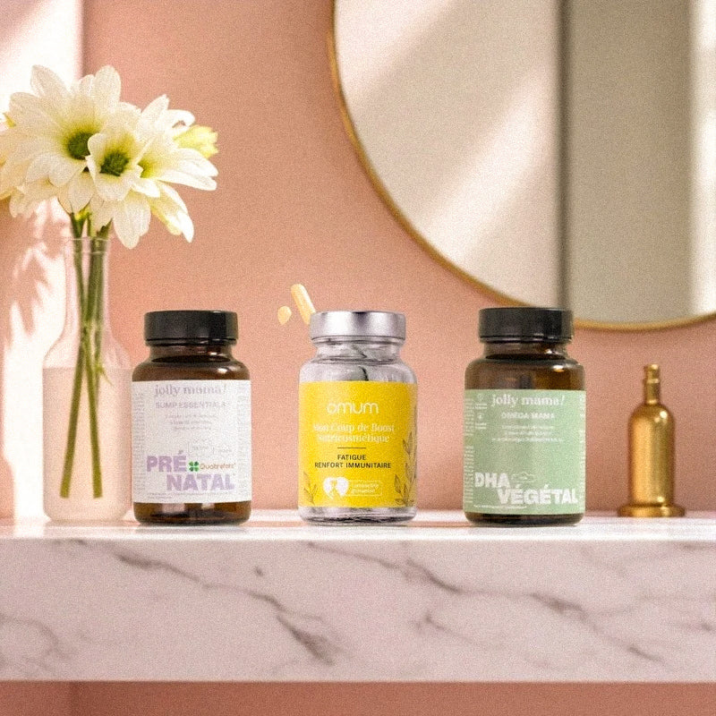Trio de compléments alimentaires pour la grossesse posés sur une étagère : Pré-natal, DHA végétal Jolly Mama et Omum Immunité, pour lutter contre la fatigue et soutenir les défenses naturelles