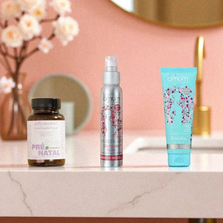 Trois soins maternité posés dans une salle de bain élégante aux tons roses et dorés, idéaux pour accompagner la grossesse en toute sécurité.