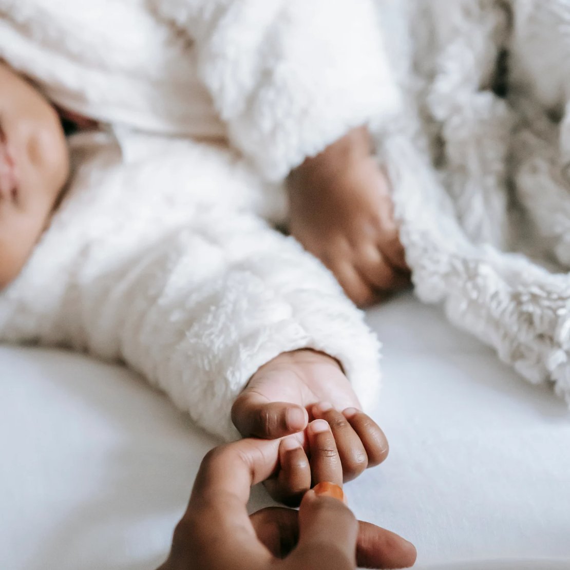 Maman qui applique un soin naturel sur la peau de son bébé, moment de tendresse et de douceur.