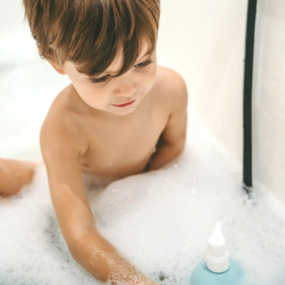 Enfant jouant dans le bain moussant avec le gel lavant Monjour, adapté dès la naissance.