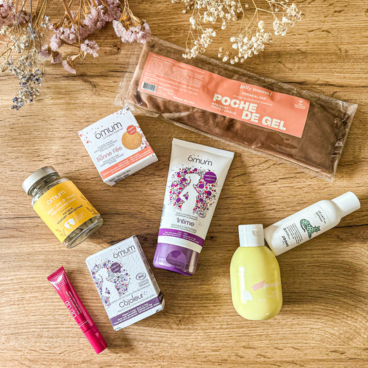 Produits post-partum naturels pour le confort de la jeune maman : complément alimentaire Omum, soins intimes, poche de gel Jolly Mama, savon solide, baume, gel lavant, et lip up dans une composition fleurie.