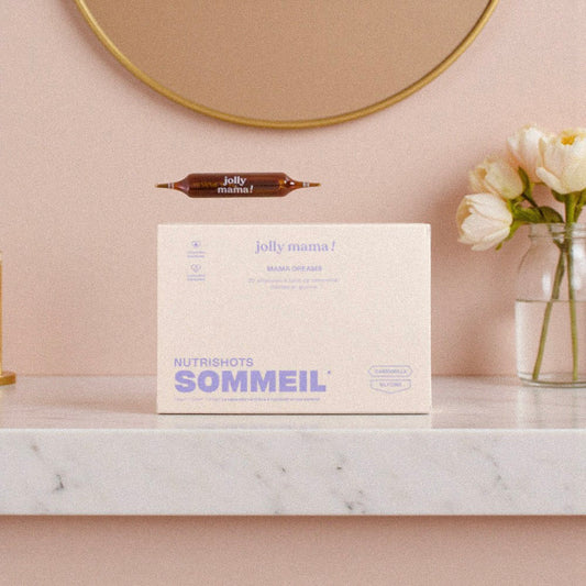 Photo du complément alimentaire Mama Dreams de Jolly Mama, format nutri-shot pour favoriser un sommeil réparateur pendant la maternité, posé sur une étagère en marbre avec des fleurs.