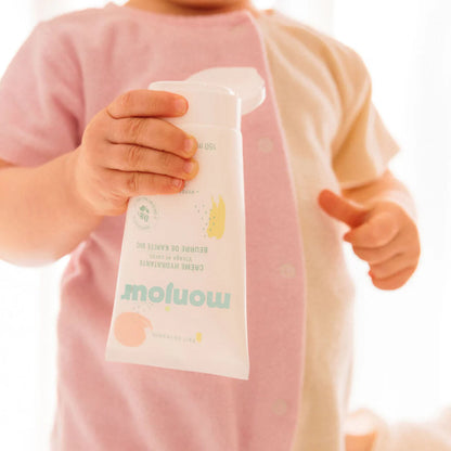 Enfant tenant un tube de crème hydratante Monjour, soin visage et corps naturel et hypoallergénique
