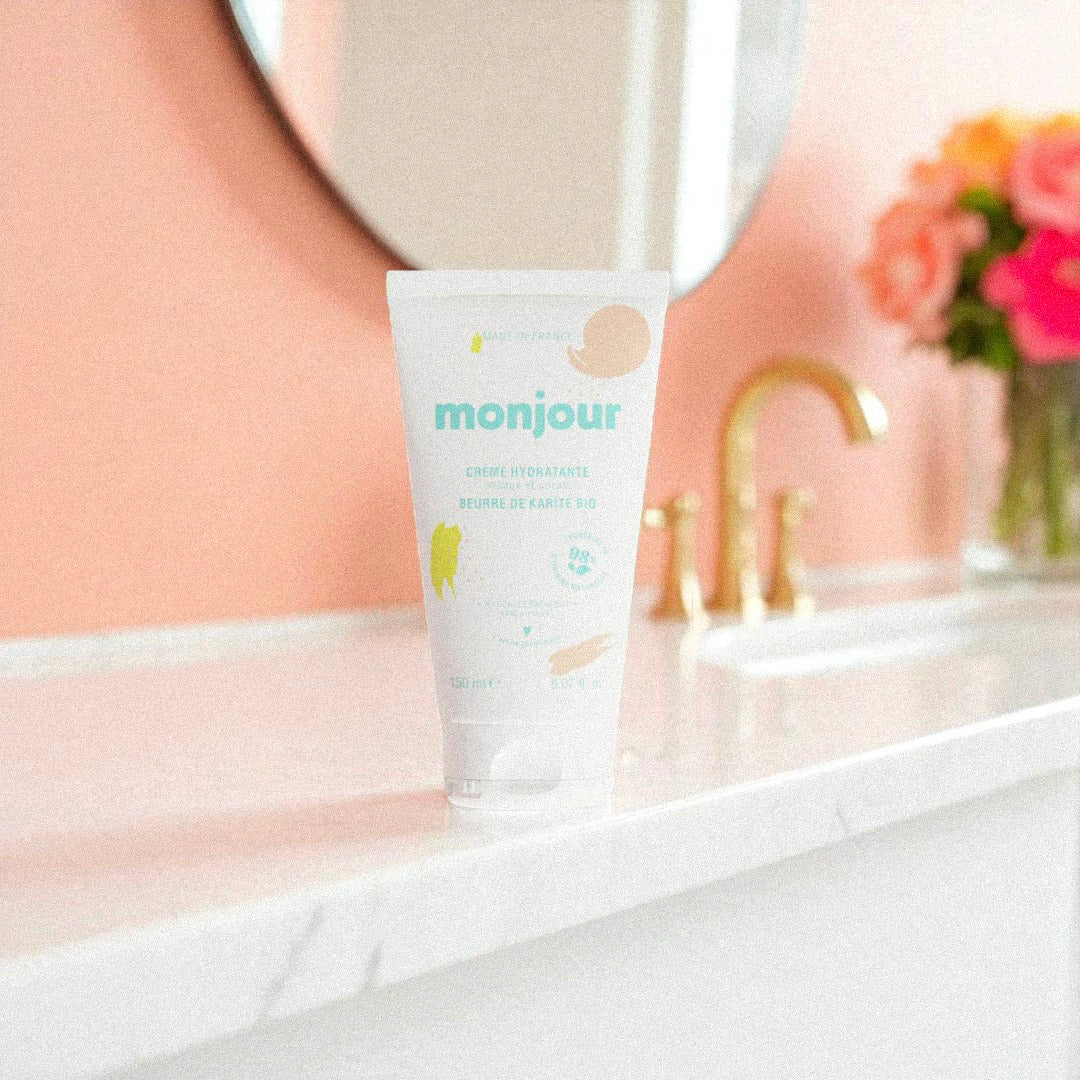 Tube de crème hydratante Monjour posé sur un lavabo en marbre, soin visage et corps naturel bébé et famille