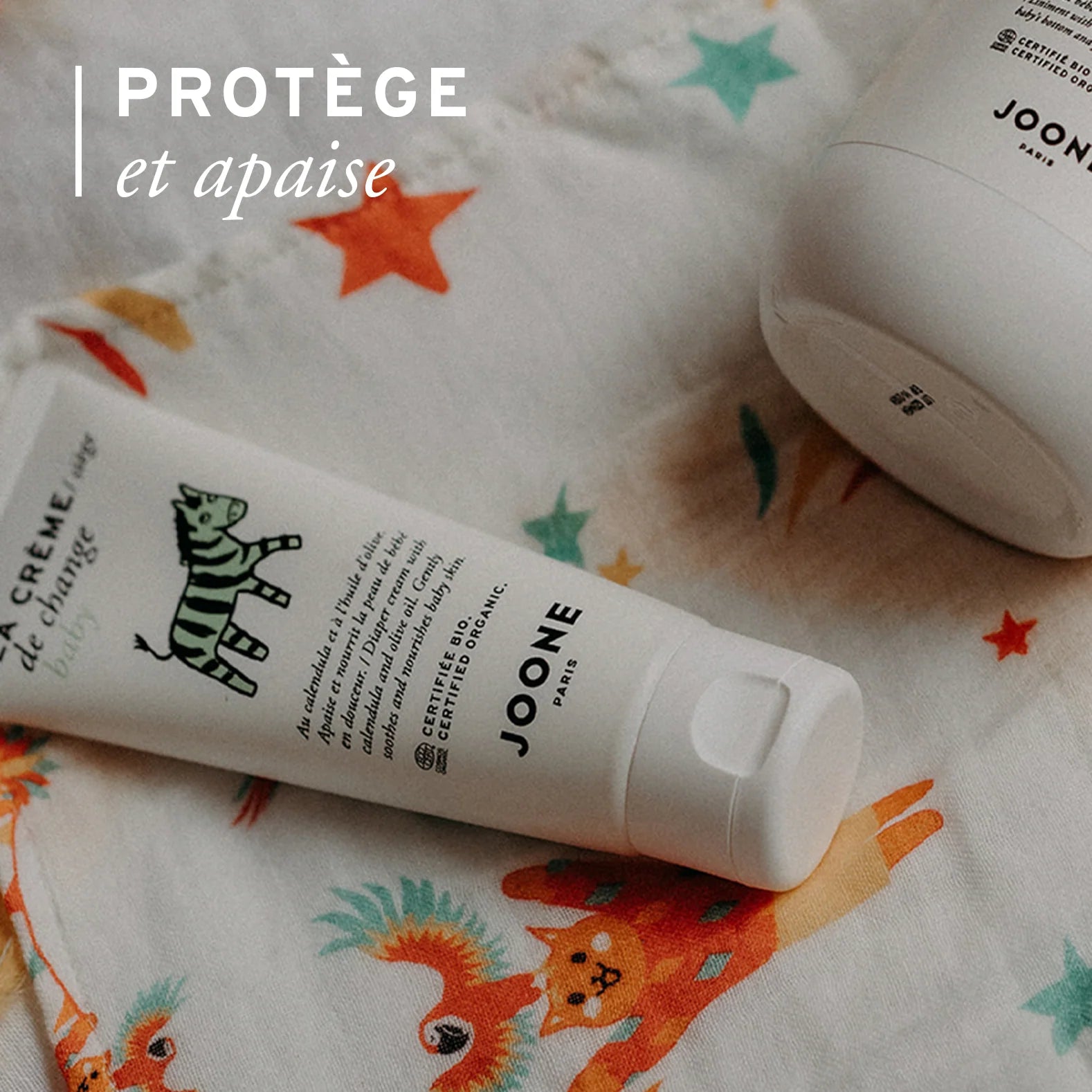 Crème de change bio Joone posée sur un tissu, protège et apaise la peau fragile du siège.