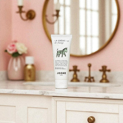 Crème de change bio Joone posée dans une salle de bain au décor rose poudré.