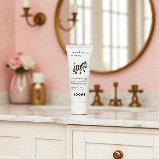 Crème de change bio Joone posée dans une salle de bain au décor rose poudré.
