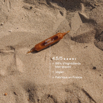 Ampoule Light Legs Jolly Mama posée sur le sable, mise en avant du côté naturel et estival de la cure.
