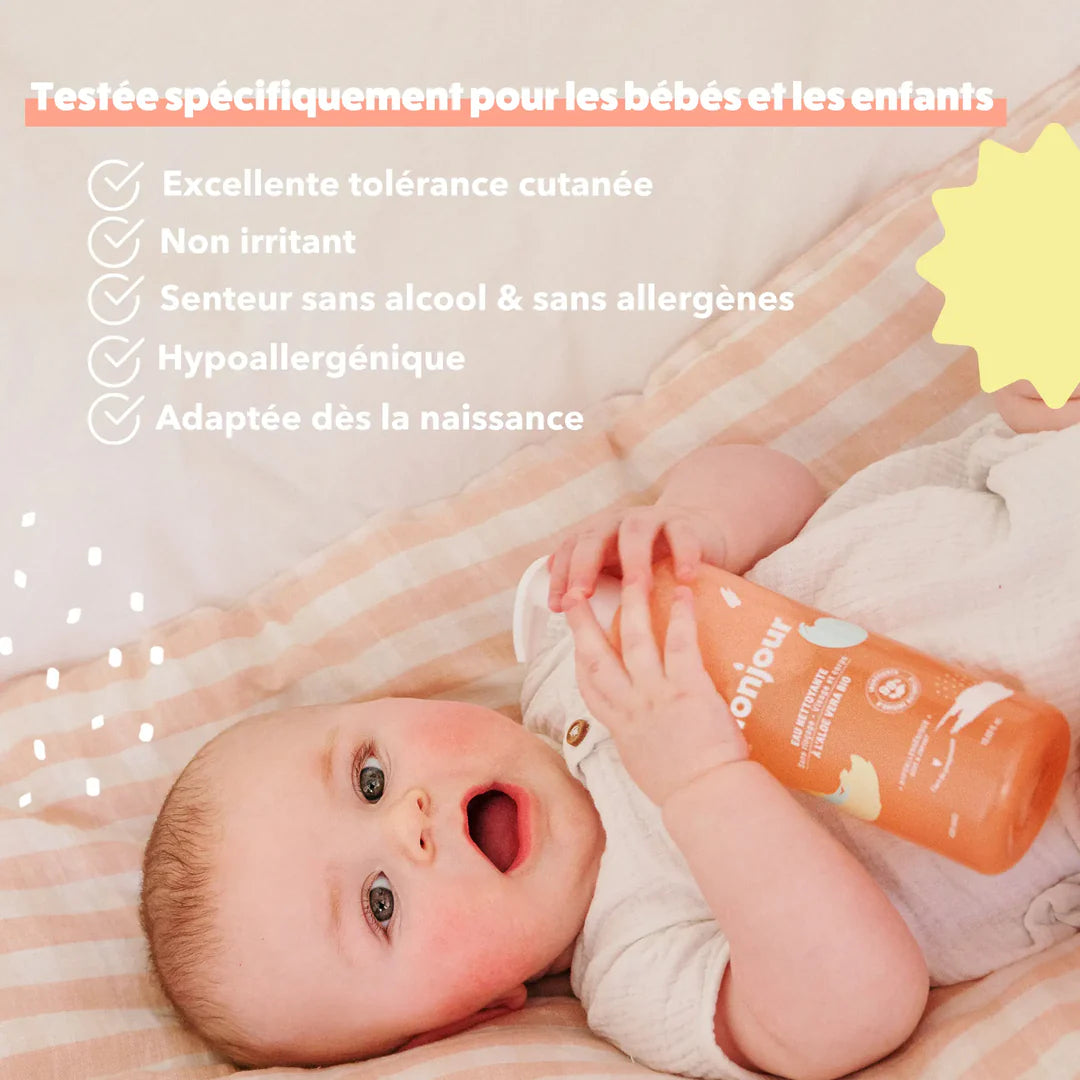 Bébé tenant le flacon d’eau nettoyante Monjour avec encadré listant les bénéfices : sans alcool, hypoallergénique, adaptée dès la naissance