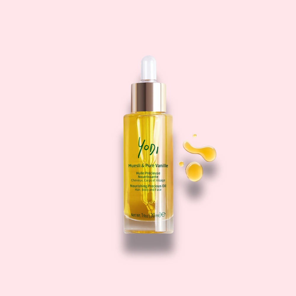 Flacon d’Huile Nourrissante Muesli Yodi posé sur un fond doux, illustrant son utilisation pour hydrater et protéger la peau sensible des mamans.