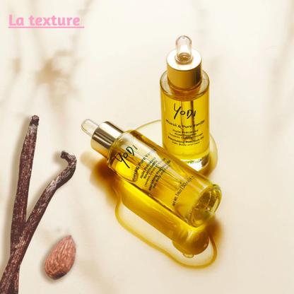 Gros plan sur quelques gouttes d’huile nourrissante Yodi s’étalant sur une peau, montrant sa texture fluide et son absorption rapide sans effet gras.