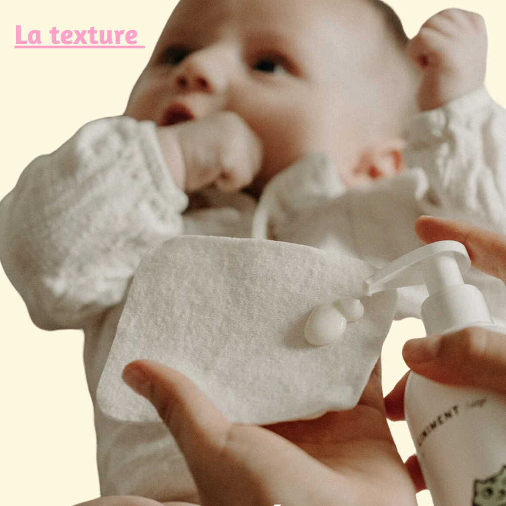 Démonstration de la texture du liniment pendant son application sur un coton, avec un bébé en arrière-plan, illustrant son utilisation pour le change.