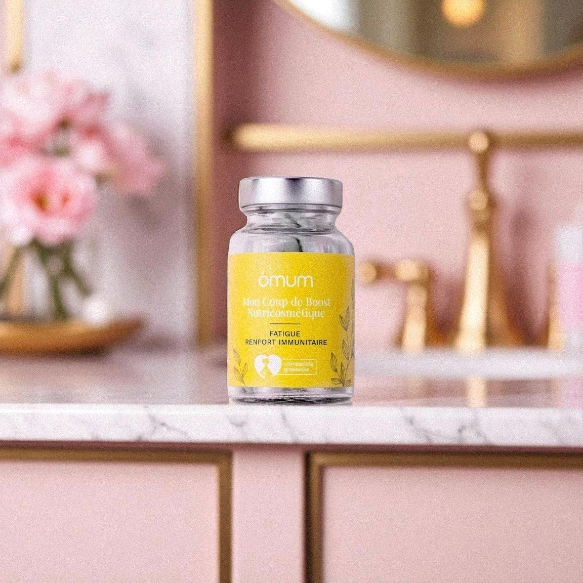 Pot de compléments alimentaires Omum Mon Coup de Boost posé sur un plan en marbre, aide à réduire la fatigue et renforcer l’immunité.