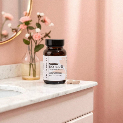 Pot du complément alimentaire No Blues sur une table marbrée, conçu pour réduire la fatigue, le stress et soutenir le moral des mamans en post-partum.
