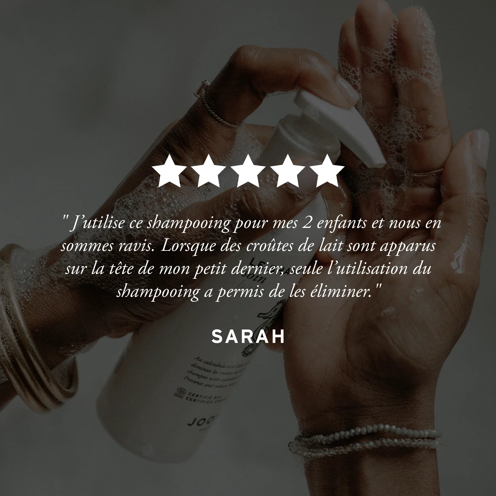 Avis client positif sur le shampoing soin bio Joone, mains tenant le flacon.