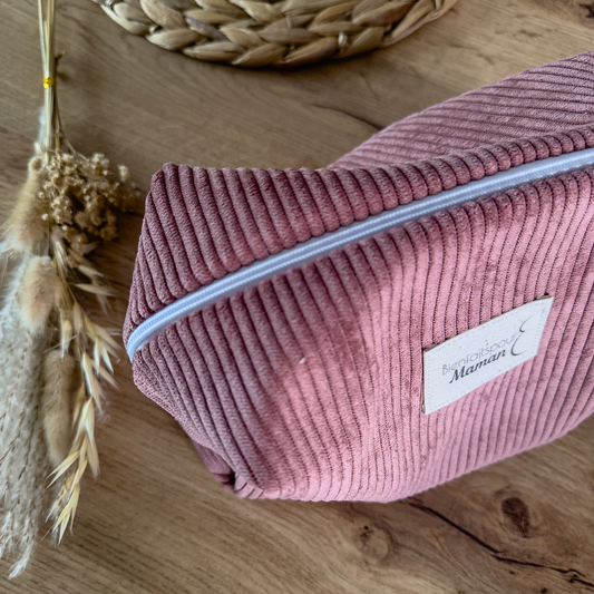 Trousse de toilette en velours rose côtelé, avec fermeture zippée et étiquette Bienfaits pour Maman visible sur le devant.